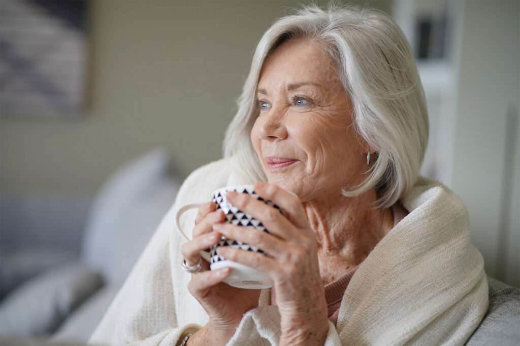 Woman with thoughtful look holding coffee cup